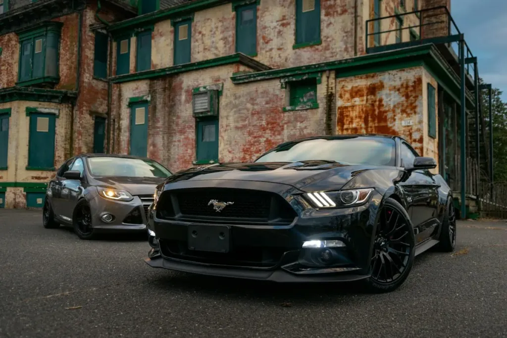 Schwarzer Mustang vor einer Backsteinfassade